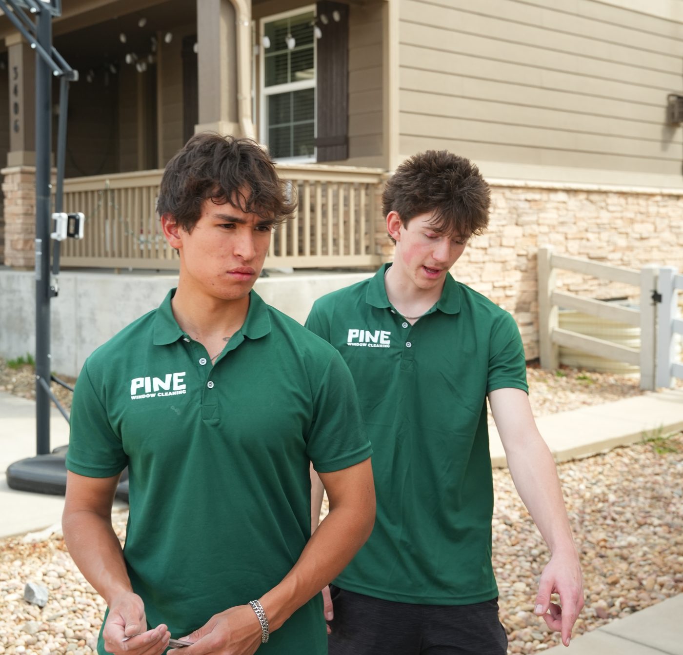 Two Pine Window Cleaning technicians in uniform outside a Broomfield home